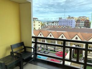 a balcony with a bench and a view of a city at Golden Sea Pattaya - SHA Extra Plus in Pattaya Central