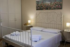een slaapkamer met een bed met witte lakens en handdoeken bij La Casa della Nonna in San Mauro Castelverde