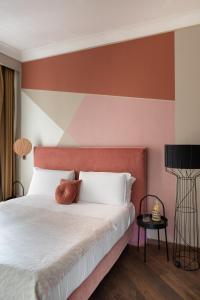 a bedroom with a white bed with a red headboard at Boutique Hotel Galatea in Rome