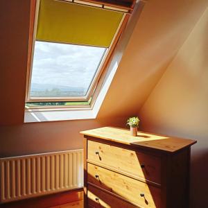 a bedroom with a window and a wooden dresser at Justosleep in Kilkenny
