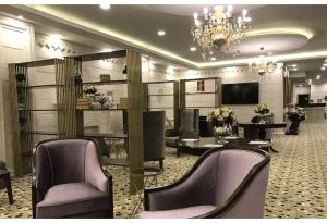 un salón con sillas y mesas moradas y una lámpara de araña en Westport Istanbul Resort & Spa Hotel, en Silivri