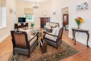 a living room with a couch and chairs and a television at Cliff Cottage Hermanus in Hermanus