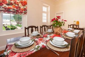 a dining room with a table with plates and dishes on it at Cliff Cottage Hermanus in Hermanus