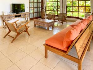 a living room with a couch and a tv at Villa Bidadari - Bali Sea Villas Beachfront and private pool in Pengastulan
