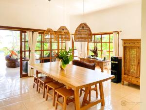 una sala da pranzo con tavolo e sedie in legno di Villa Bidadari - Bali Sea Villas Beachfront and private pool a Pengastulan