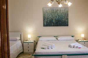 een slaapkamer met 2 bedden en een schilderij aan de muur bij La Casa della Nonna in San Mauro Castelverde