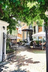 ein Tor zu einem Haus mit Tischen und Stühlen in der Unterkunft Residence Villa Barrio in Bukarest
