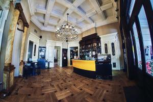 a lobby with a bar and a chandelier at Residence Villa Barrio in Bucharest