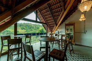 a restaurant with tables and chairs and a large window at Antiquus ApartHotel in Guaramiranga