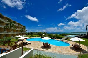 a pool with chairs and umbrellas in a resort at EXES Ishigaki in Ishigaki Island