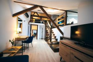 a living room with a television and a staircase at Residence Villa Barrio in Bucharest