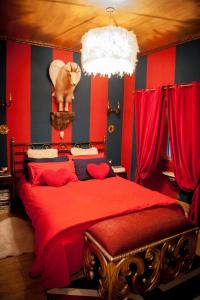 a bedroom with a red bed with a cat on the wall at Repubblica Di Oz Rooms in Varese