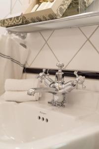 ein Waschbecken mit einem silbernen Wasserhahn und Handtüchern in der Unterkunft Dalen Hotel in Dalen