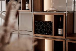 - une étagère avec des bouteilles de vin et un verre dans l'établissement Bio Weingut Matthias Schnabl, à Gamlitz