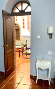 einen Eingang zu einem Zimmer mit einer Tür und einem Tisch in der Unterkunft Patio de la Plateria in Córdoba
