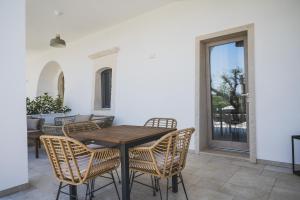 a patio with a wooden table and chairs at Dimorae Camà in Cisternino