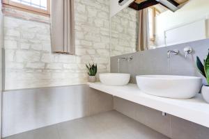 2 lavabos en un baño con una pared de piedra en Villa Vetta Marina - My Extra Home, en Sirolo