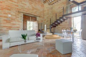 salon z białą kanapą i ceglaną ścianą w obiekcie Villa Vetta Marina - My Extra Home w mieście Sirolo