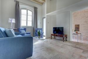 sala de estar con sofá azul y TV en Villa Vetta Marina - My Extra Home, en Sirolo