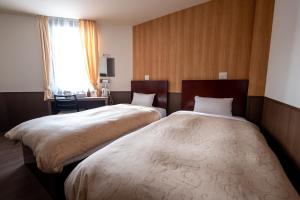 Postel nebo postele na pokoji v ubytování Hotel Ekichika Nagahoribashi