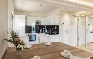 uma cozinha com uma mesa de madeira e armários brancos em Prora Solitaire Sunny Suite em Binz