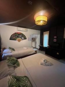 a bedroom with two beds and a chandelier at Sonic Hill Koh Phangan in Haad Rin +15 photos