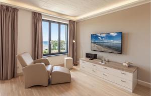 uma sala de estar com uma televisão e um sofá e cadeiras em Prora Solitaire Sunny Suite em Binz
