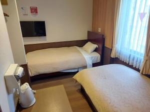 Postel nebo postele na pokoji v ubytování Hotel Ekichika Nagahoribashi