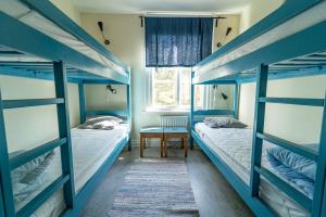 two beds in a room with blue bunk beds at Hostel Utö in Utögruvor