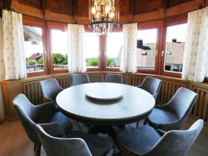 uma sala de jantar com uma mesa e cadeiras e um lustre em Haus Panoramablick - Fewo Alpensicht, 4 Schlafzimmer, Höchenschwand em Höchenschwand