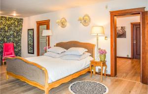 a bedroom with a large bed and a red chair at Beautiful Home In Golczewo in Golczewo +18 photos
