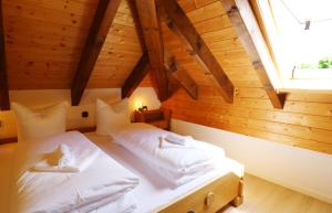 1 Schlafzimmer mit 2 Betten in einem hölzernen Dachgeschoss in der Unterkunft Haus Panoramablick - Fewo Alpenblick, Höchenschwand in Höchenschwand