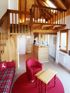 ein Wohnzimmer mit einem roten Stuhl und einem Tisch in der Unterkunft Haus Panoramablick - Fewo Alpenblick, Höchenschwand in Höchenschwand