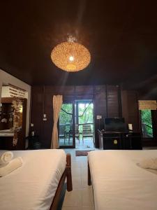 a bedroom with two beds and a chandelier at Sonic Hill Koh Phangan in Haad Rin