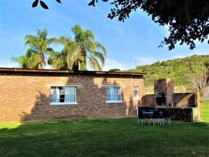 a brick building with chairs in front of it at Summerville Place in Addo