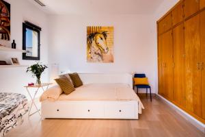 a bedroom with a bed with a painting of a horse on the wall at Anfitrión Sevilla in Seville
