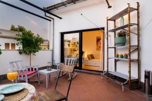 a room with a patio with a table and chairs at Anfitrión Sevilla in Seville