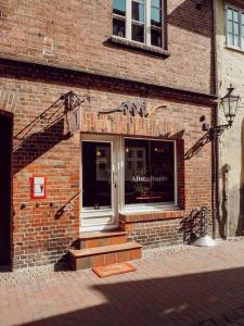 ein Backsteingebäude mit einem Eingang zu einem Geschäft in der Unterkunft Altstadt Suite in Lüneburg