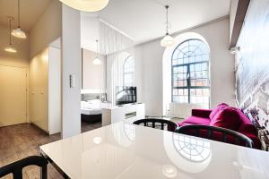 uma sala de estar com uma mesa branca e cadeiras em Loft Glamour by LookAp em Lódź