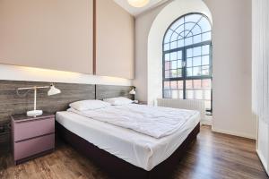 Un dormitorio con una cama grande y una ventana en Loft Glamour by LookAp, en Łódź