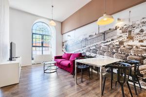 a living room with a pink couch and a table at Loft Glamour by LookAp in Łódź
