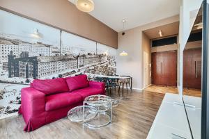 uma sala de estar com um sofá vermelho e uma mesa em Loft Glamour by LookAp em Lódź