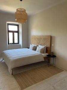 a bedroom with a large white bed and a window at Villa Kapela in Zlarin