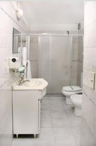 ブエノスアイレスにあるHotel Lueyの洗面台とトイレを備えた白いバスルーム +29枚の写真