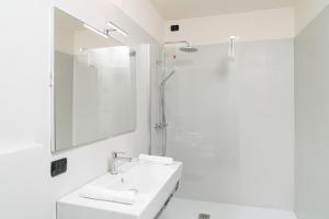 a white bathroom with a sink and a mirror at Gustificio in Carmignano di Brenta