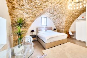 une chambre avec un lit et un mur en pierre dans l'établissement David & Yossef Luxury Rentals - Tel Aviv House Residence, à Tel Aviv