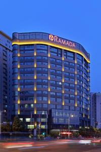 een hoog gebouw met een bord erop bij Ramada Changzhou North Hotel in Changzhou