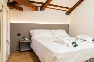 Schlafzimmer mit einem Bett mit weißer Bettwäsche und einem Tisch in der Unterkunft Gustificio in Carmignano di Brenta