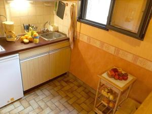 a kitchen with a sink and a table with fruit on it at Studio Bagnères-de-Luchon, 1 pièce, 2 personnes - FR-1-313-120 in Luchon