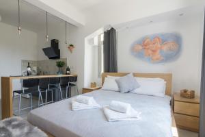 ein Schlafzimmer mit einem Bett mit weißen Handtüchern darauf in der Unterkunft Nereid Apartment in Athen